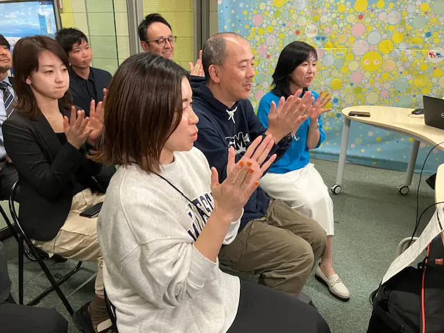 ラジオのスタッフとともに拍手を送る