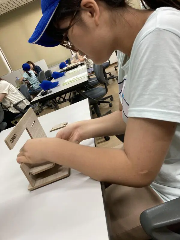 Sion
ドアの製造工場を見学しました。工場内は暑く、見学だけで汗びっしょりになりました。ここで働いている人たちは大変だなぁと思いました。見学の後はドアノブを取り付ける仕事を体験しました。最後にドアの製造時に余った木でスマホやメガネのスタンドを作りました。力いっぱいはめ込むと、上手くできました。楽しかったです。将来、家を建てる事があったら、「ドアは大建工業で」と言いたいなと思いました。