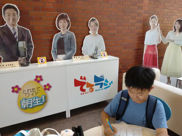 たけたけ
学校の校内放送で話したことはあるけど、県内全体に放送されるラジオに出るのはとても緊張しました。まずは、ジングルを作りました。他の子たちと協力していいものができました。ラジオの本番は緊張してうまく言えないこともあったけど、無事に終わったときはホッとしました。
また、テレビのアナウンサーのようにニュースを読む体験もしました。アナウンサーの方が優しく教えてくれて安心しました。今回の体験をして、アナウンサーのお仕事もいいなぁと思いました。