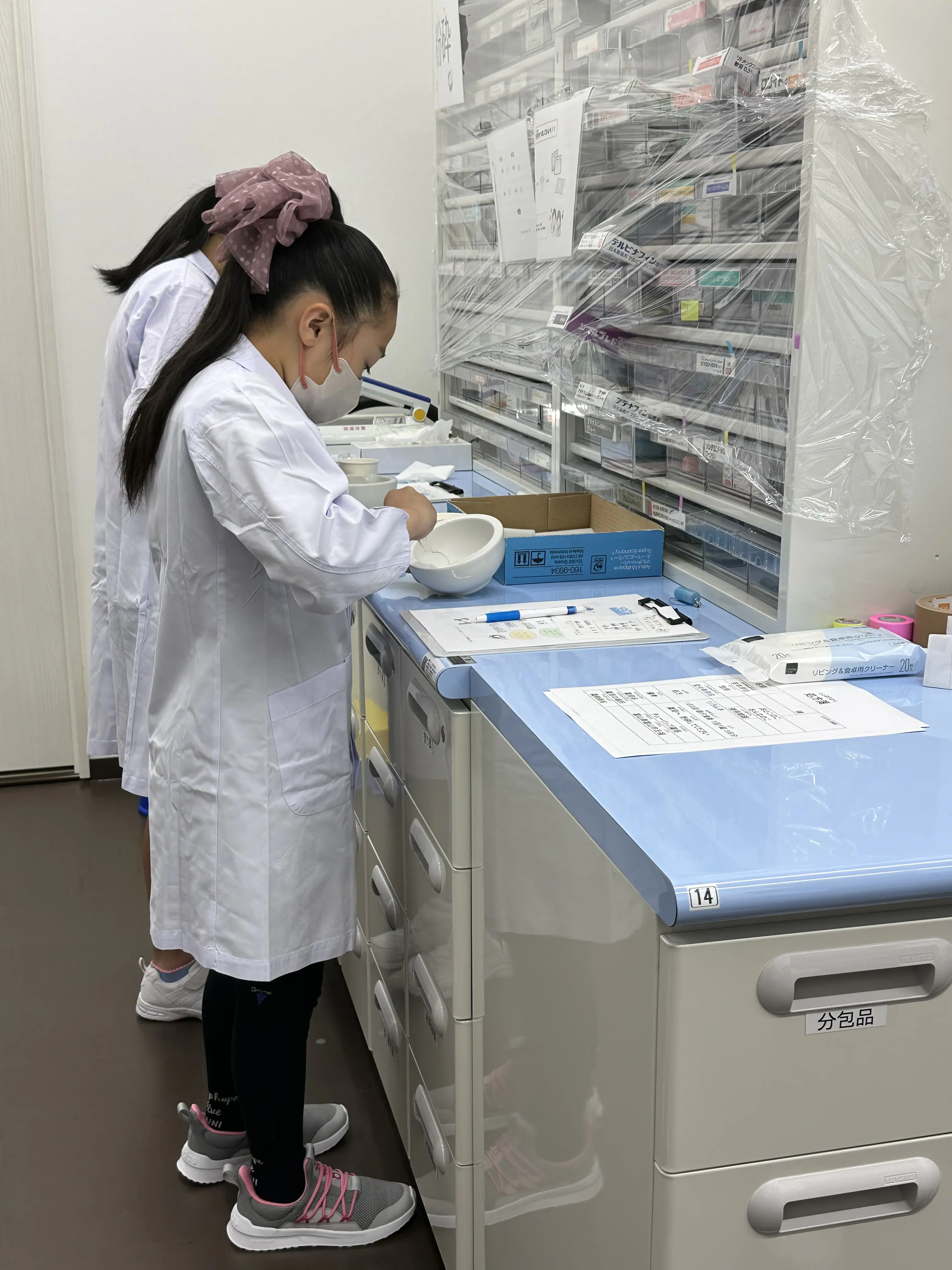 まいまい
白衣を着て、水剤の調合や、錠剤の粉砕体験、軟膏を容器に詰めたりしました。正確に測るのに集中力がいります。軟膏を混ぜて容器に入れるのがとても難しかったです。分包機という、お薬を一つ一つ袋に分けて袋詰めしてくれる機械にも触ることができ、楽しかったです。薬剤師のお仕事に実際にやってみて、ますます薬剤師になりたいと思いました。

